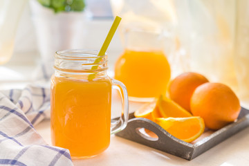 Orange juice with a glass cup and fresh fruit on a table breakfast in a summer afternoon in rustic style