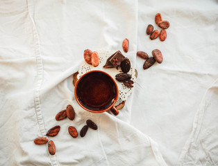 Raw cocoa (cacao) beans, black chocolate on brown sacking, top view. Good morning concept.Space for...