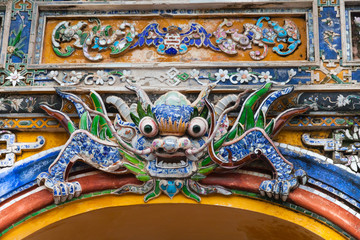 Vietnam, Hue. Dragon decoration decorated with pieces from broken ceramic dishes at Imperial City on the one of five entrance gates to the Forbidden city complex in Citadel.