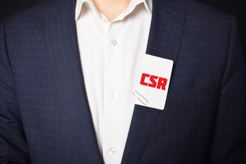 Businessman shows business card with the inscription:CSR