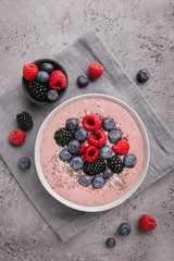 Smoothie bowl on white plate on grey concrete background