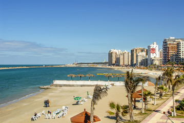 Alexandria, Egypt, 21 February 2018: View of Alexandria harbor, beach, palms and buildings
