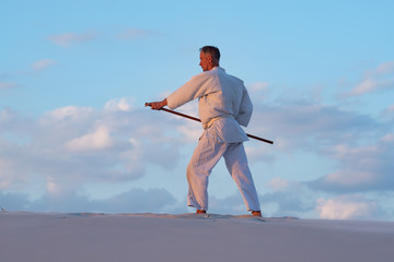 Man is practicing martial arts with a traditional Japanese weapon