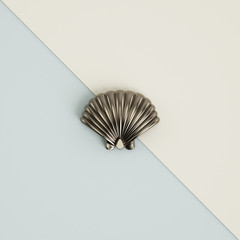 Silver seashell sculpture on pastel blue-ivory background.. 3d rendering