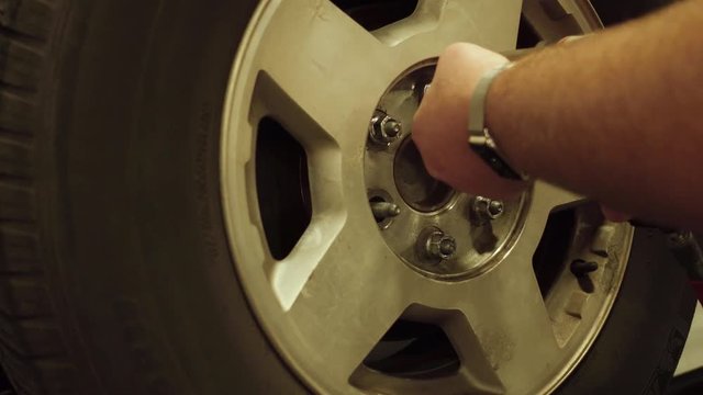Technician Removing Lug Nuts From Wheel on a Vehicle