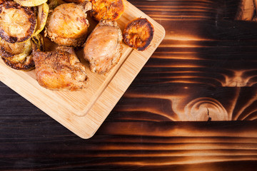 Healthy and delicious dinner made of fried chicken and grilled vegetables on wooden plate