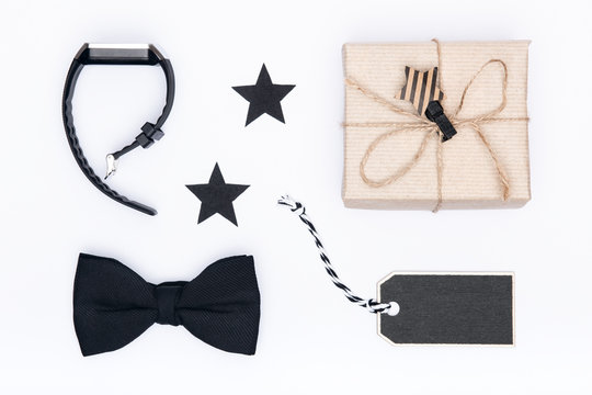 Happy Father's Day Background. Beautiful present, black bow tie and watch on white background flat lay. Fathers day still life setup. - Powered by Adobe