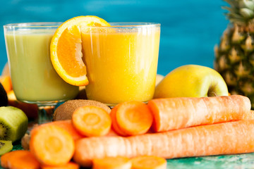 Healthy and raw detox juices next to fruits and vegetables