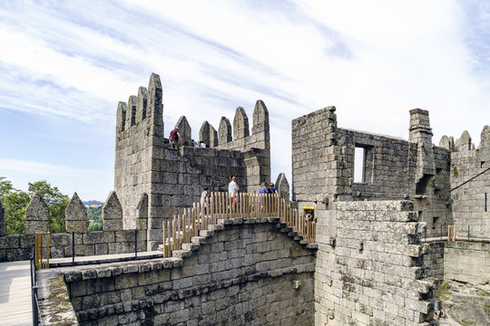 Guimaraes, Portugal. August 14, 2017: People walking through the walls of the castle of King Afonso Henriques built in the eleventh century and in good condition next to a watchtower