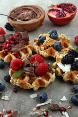 Belgian waffles with pomegranate and raspberries, homemade healthy breakfast with mint