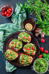 Bruschetta with fresh pesto, mozzarella and cherry tomatoes on cutting board