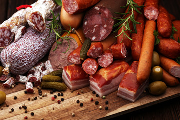 Food tray with delicious salami, ham,  fresh sausages, cucumber and herbs. Meat platter