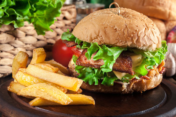 Delicious burger with chicken, bacon, tomato and cheese