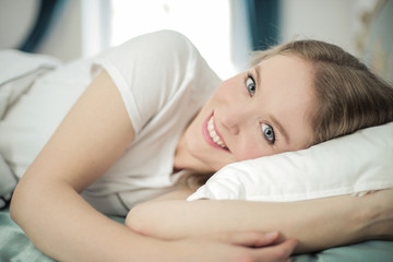 Fototapeta na wymiar Portrait of fresh faced girl lying in bed