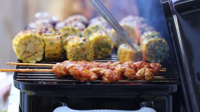 Vegan barbecue with seitan grill sticks, corn cobs and stuffed mushrooms 