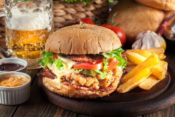 Delicious burger with chicken, bacon, tomato and cheese