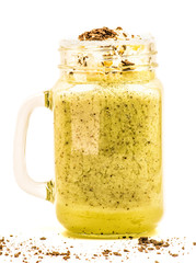 kiwi milkshake in mason jar with creme and chocolate on top isolated on white background