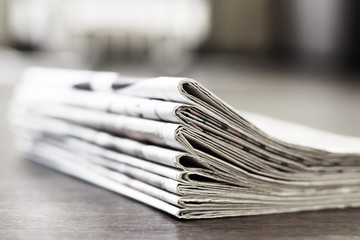 Folded newspapers stacked in pile. Periodic publications with actual news in business office. Daily...