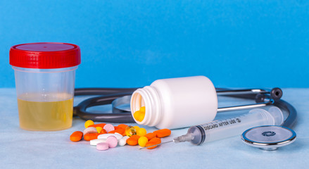 Urine container,  syringe, phonedoscope and colored pills