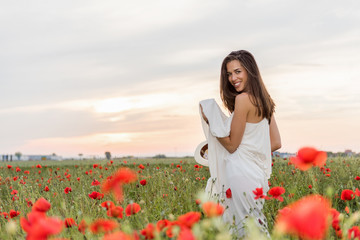 Fototapeta na wymiar Happy woman in the field of red poppies