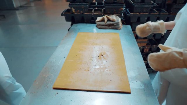 production of bakery food products with fresh products. The baker pulls out the hot bread from the mold and puts it on the racks. The bread-baking plant.