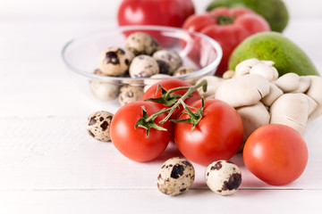 Fototapeta na wymiar Healthy Diet Food on White Background Vegetables Tomatoes Peppers Green leaves Mushrooms Eggs Copy Space Ingredients for Salad