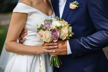 Wedding photo. Bride and groom holding wedding bouquet