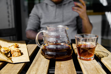Drinking alternatively brewed coffee at the sunny street cafe from glasses.