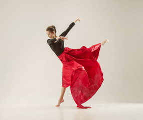 Modern ballet dancer dancing in full body on white studio background.