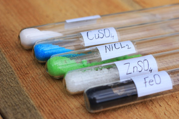 Crystals of salts of different structure and colors in test tubes.