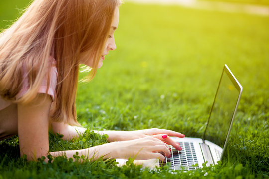 Girl Student Lying On Grass With Laptop