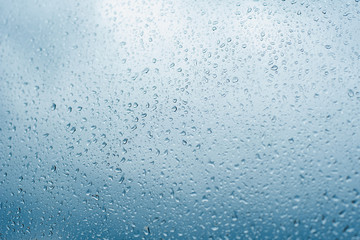 Drops of rain on the window glass Shallow DOF. Window after rain. Blue Water background with water drops