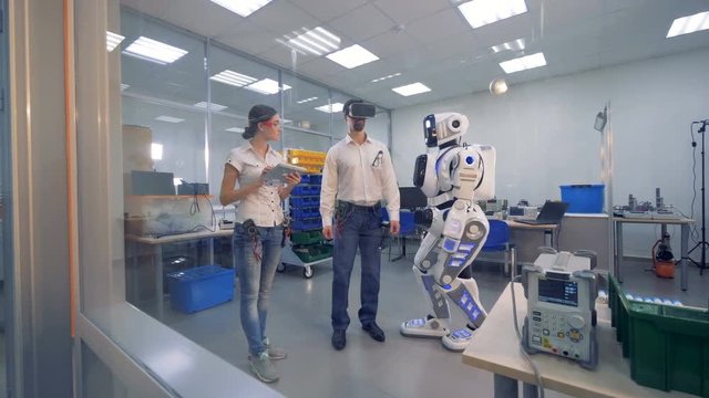 Robot is moving after an engineer in virtual glasses