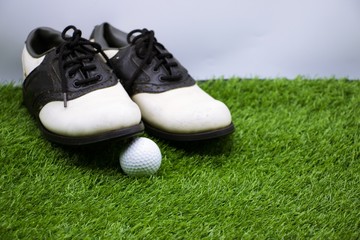 golf shoes and golf ball are on green grass