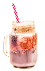 blueberry and raspberry milkshake in mason jar with drinking straw isolated on white background