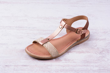 Obraz premium Women's sandal on white wooden background.