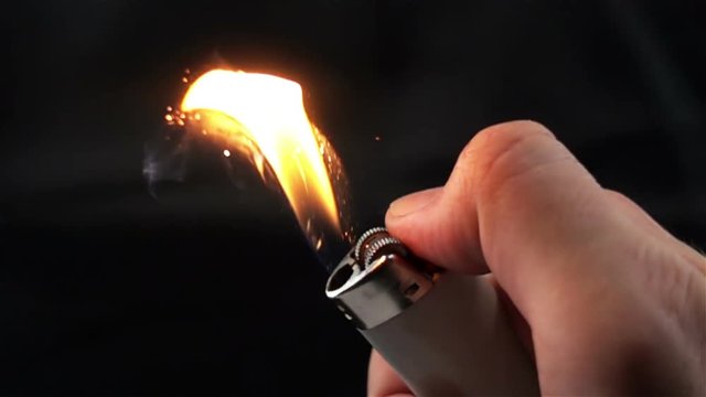 Slow Motion Video of Using a Lighter at Night with Sparkles and Fire