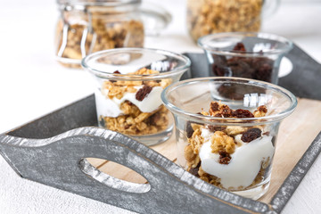 Bowl of homemade muesli with nuts, berries, dried fruits, milk and honey on white wooden background. Healthy breakfast. top view