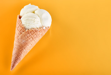 ice cream balls with colored sugar sprinkles in a Waffle Cone on a yellow Background. Vanilla ice cream in a waffle cone.