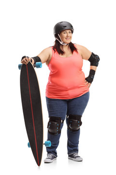 Overweight woman wearing protective gear and holding a longboard