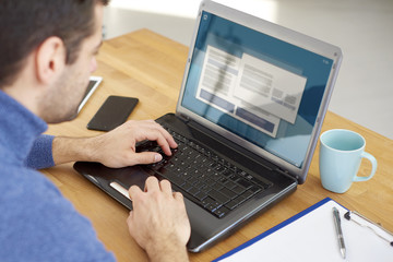Close-up and rear view shot of businessman typing on computer