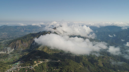 Aerial view of mountains covered forest, trees in clouds. Cordillera region. Luzon, Philippines. Slopes of mountains with evergreen vegetation. Mountainous tropical landscape.