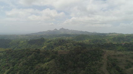 Aerial view of mountains covered forest, trees. Cordillera region. Luzon, Philippines. Slopes of mountains with evergreen vegetation. Mountainous tropical landscape.