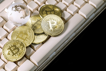 Glass globe and Bitcoin Cryptocurrency on keyboard. Business concept