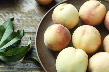ripe peaches with leaves on the table