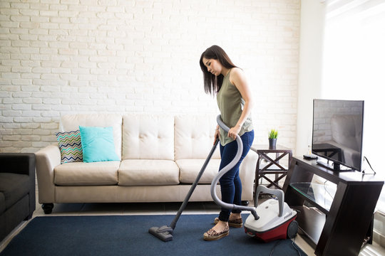 Tired young woman cleaning house dust