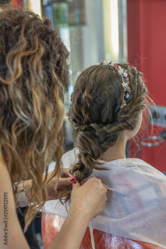 Peluquera Rematando Una Trenza En El Peinado De Una Niña De Peluquera Rematando Una Trenza En El Peinado De Una Niña De