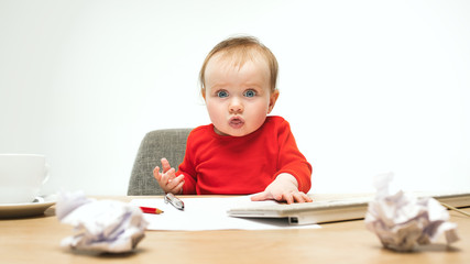 Happy child baby girl toddler sitting with keyboard of computer isolated on a white background