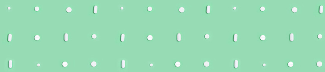 panorama white pills round and oval  on a green background
