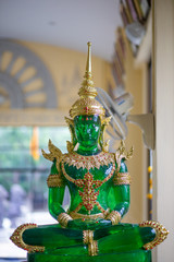 Jade Buddha with Green and Gold sitting on blurred Background